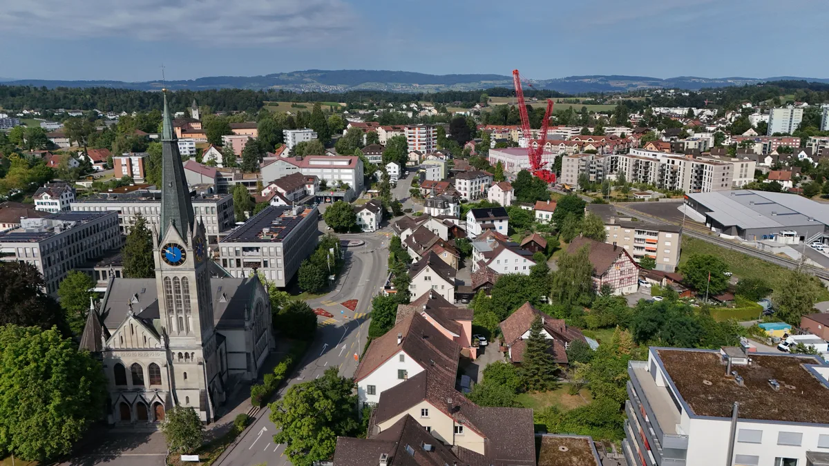 Der Kran erreicht fast die Höhe der Kirchturmspitze von Oberwetzikon. Der fertig montierte Raupenkran über den Dächern von Wetzikon.